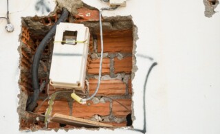 Unfinished wiring and electricity meter on a wall