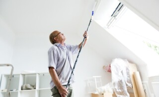 Senior man makes home improvement with new paint