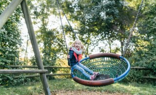 Girl Swinging At Playground
