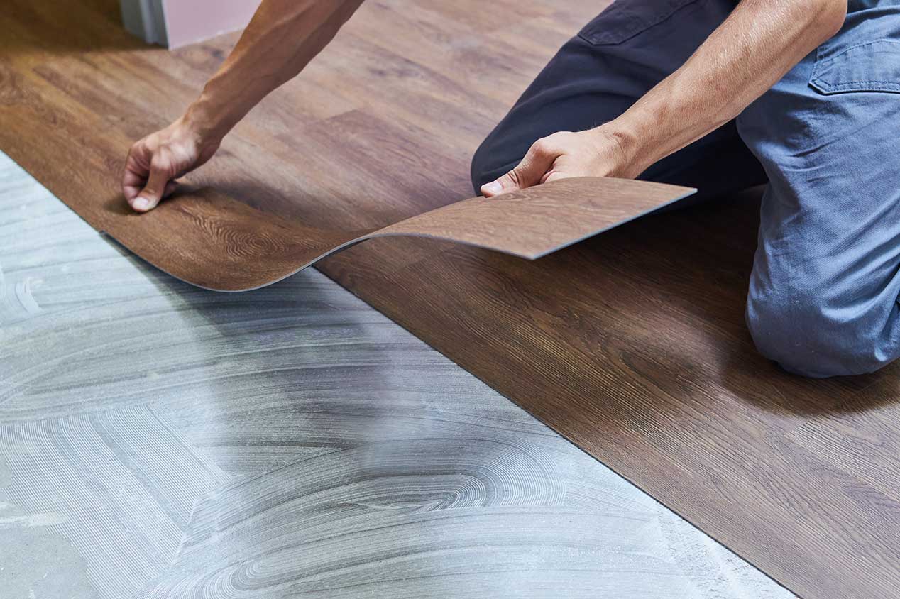 Person installing vinyl flooring at home