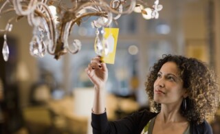Woman Looking at Price Tag of Chandelier