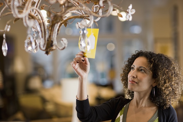 Woman Looking at Price Tag of Chandelier