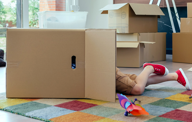 Child hiding or playing in moving box
