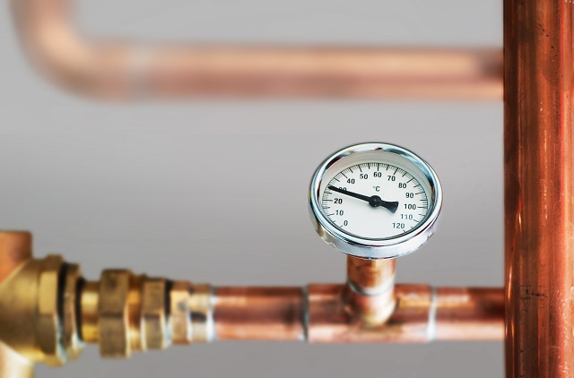 Heating system's cooper pipes with Thermometer on a copper pipe