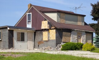 Damaged Destroyed Boarded-Up Abandoned House