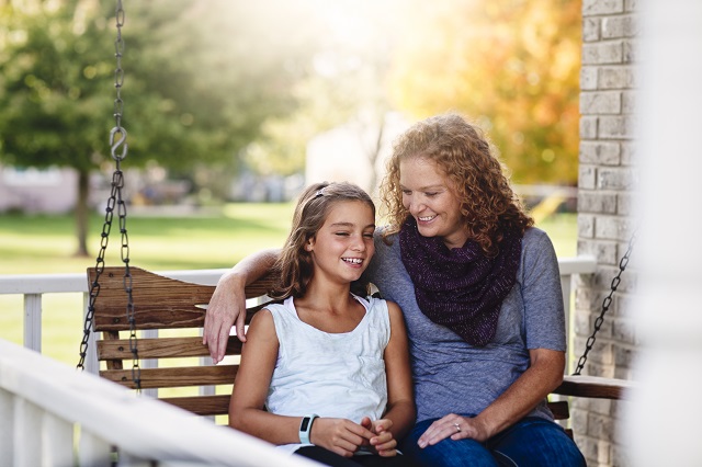 Aunt and niece sitting on a finished porch swing