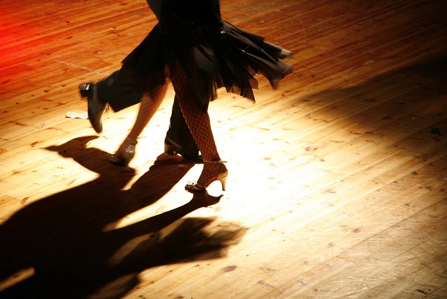 Tangoing couple alone on hardwood floor