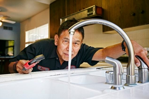 Plumber fixing a kitchen sink