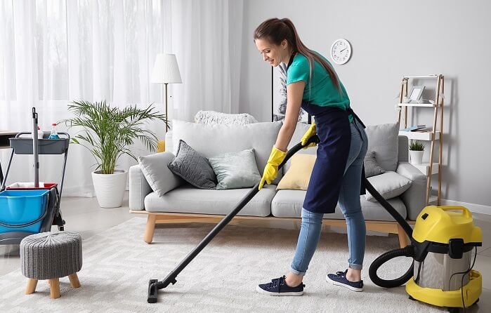 professional maid vacuuming a carpet