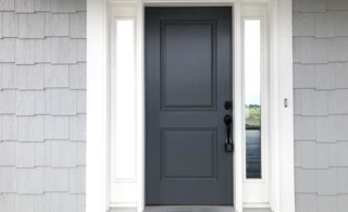 Charcoal Grey Front Door Surrounded by White Trip and Greige Shingle Siding