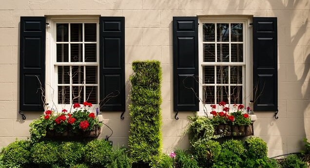 black exterior shutters on a cream-colored house