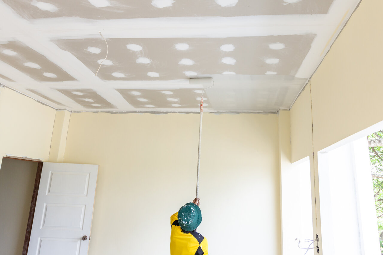 professional painter using roller on ceiling