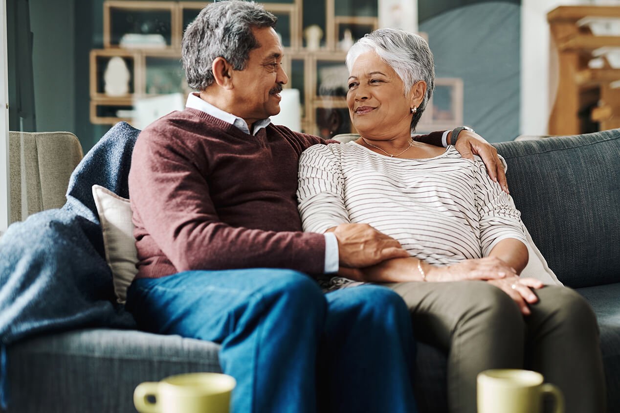 Couple sitting on couch together smiling