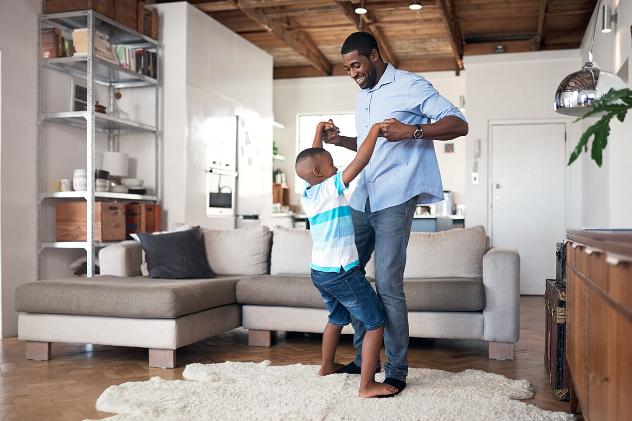 Father and son dancing in living room