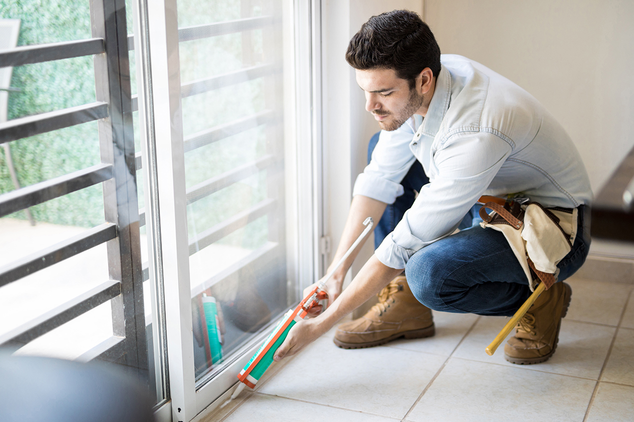 Man applying sealant to window frame