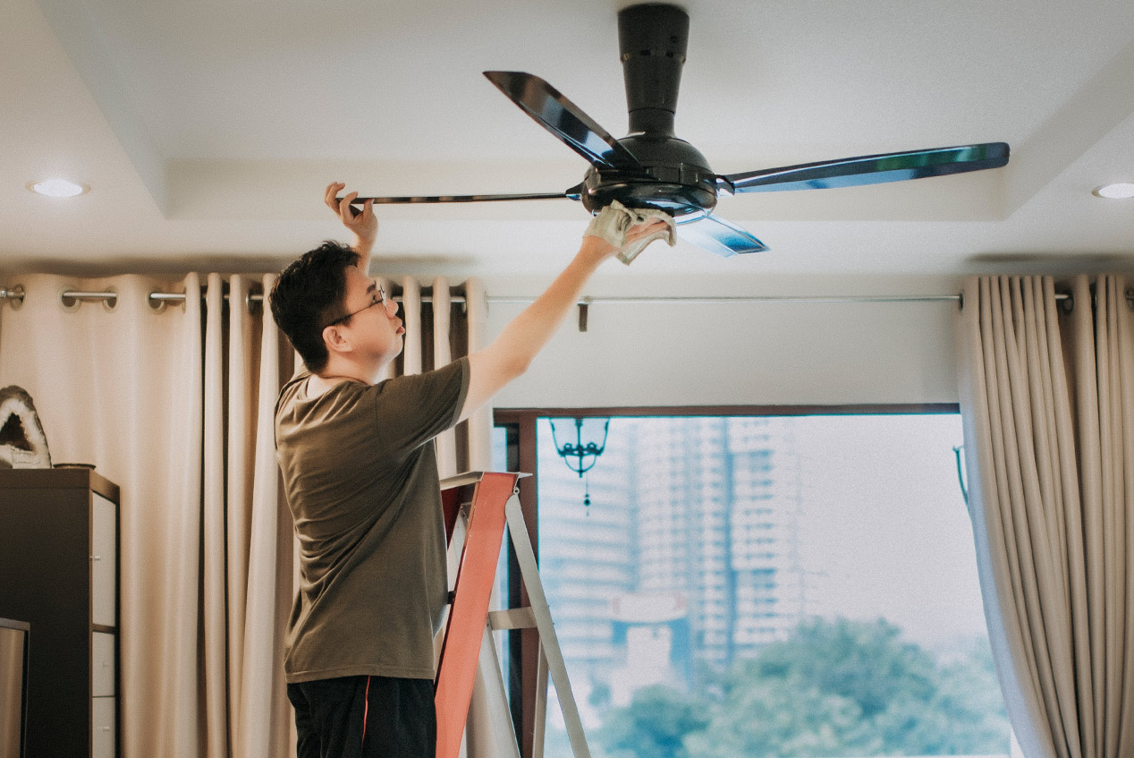 man cleaning ceiling fan