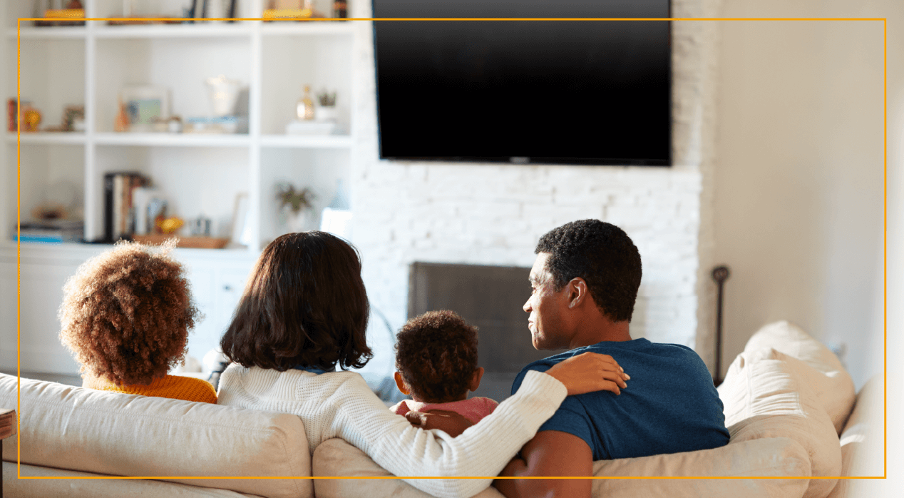 family sitting on couch about to watch a movie