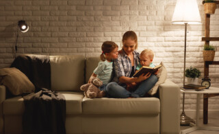mother reading to children on couch