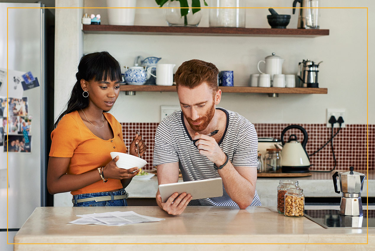 couple in kitchen checking tablet together 