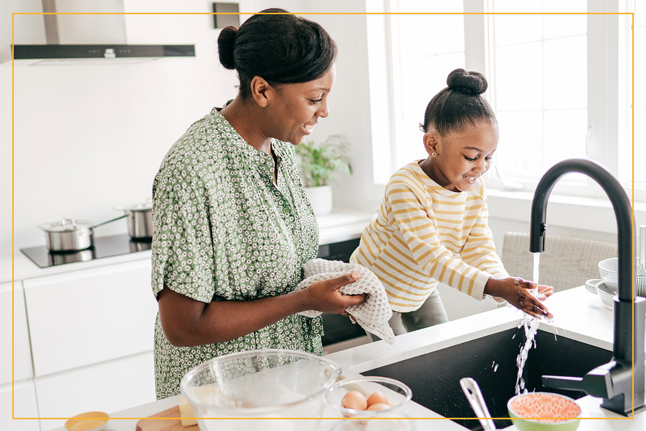 mom and daughter using sink in kitchen