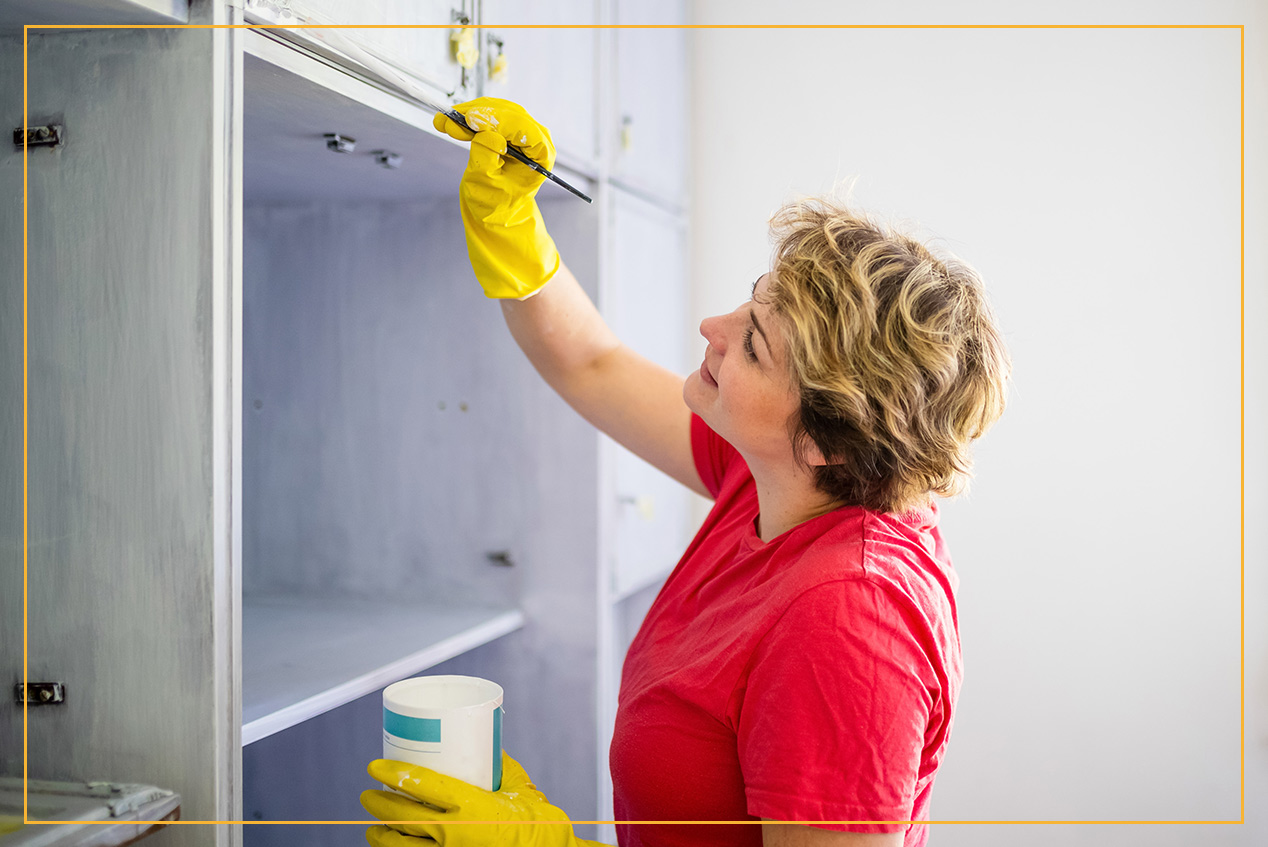 woman painting cabinet 