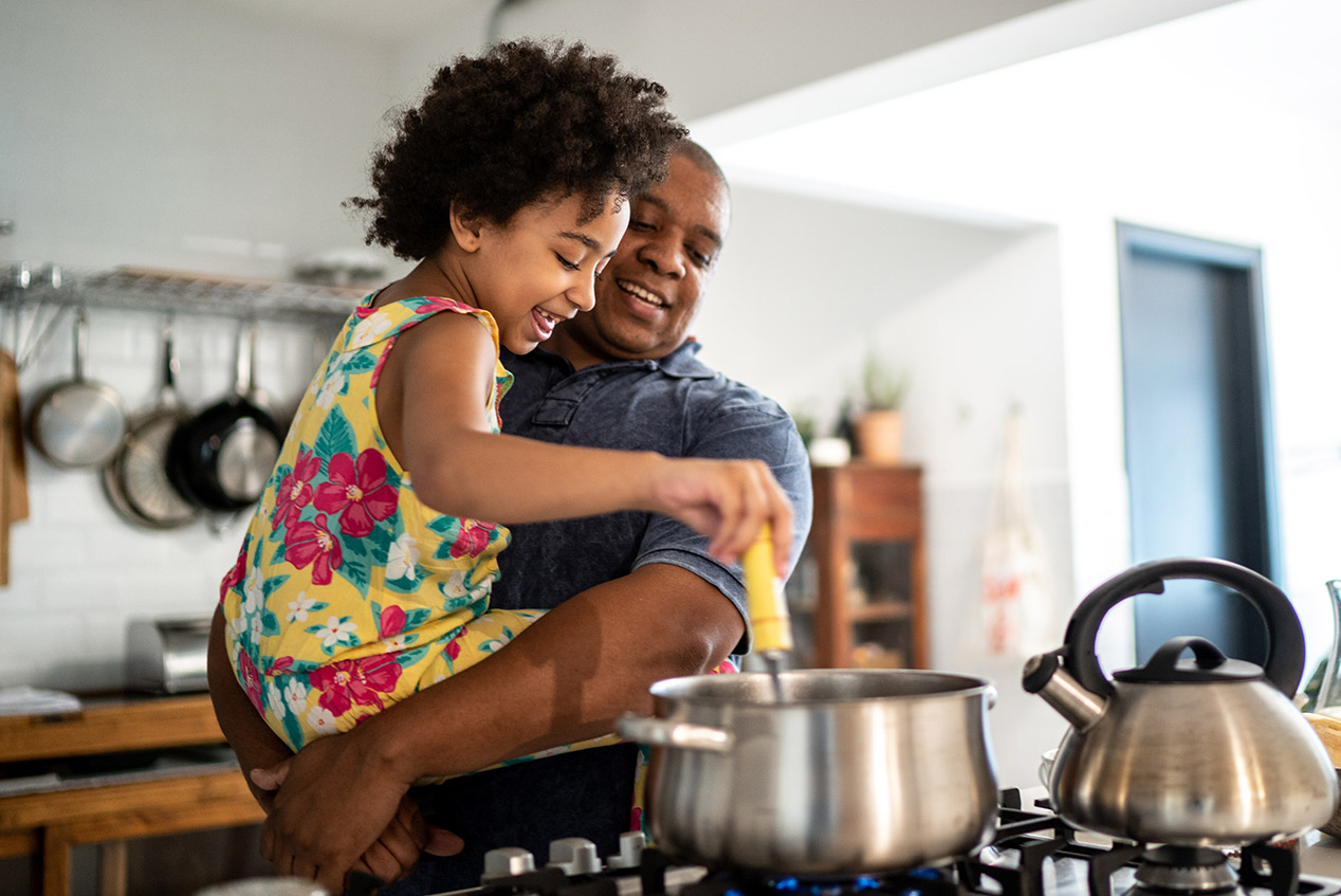 father and daughter making dinner in kitchen