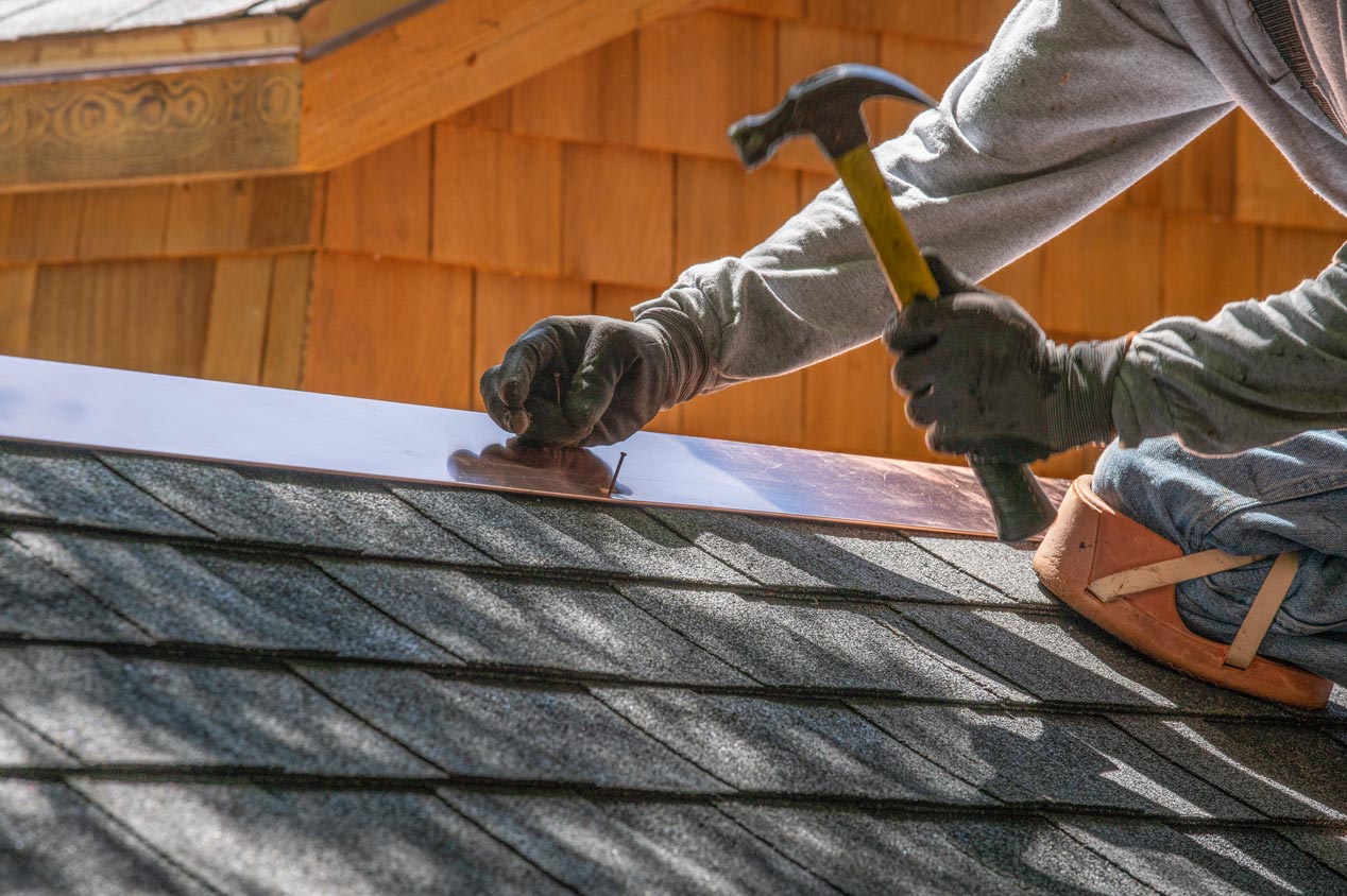 Close-up of professional installing new asphalt shingles