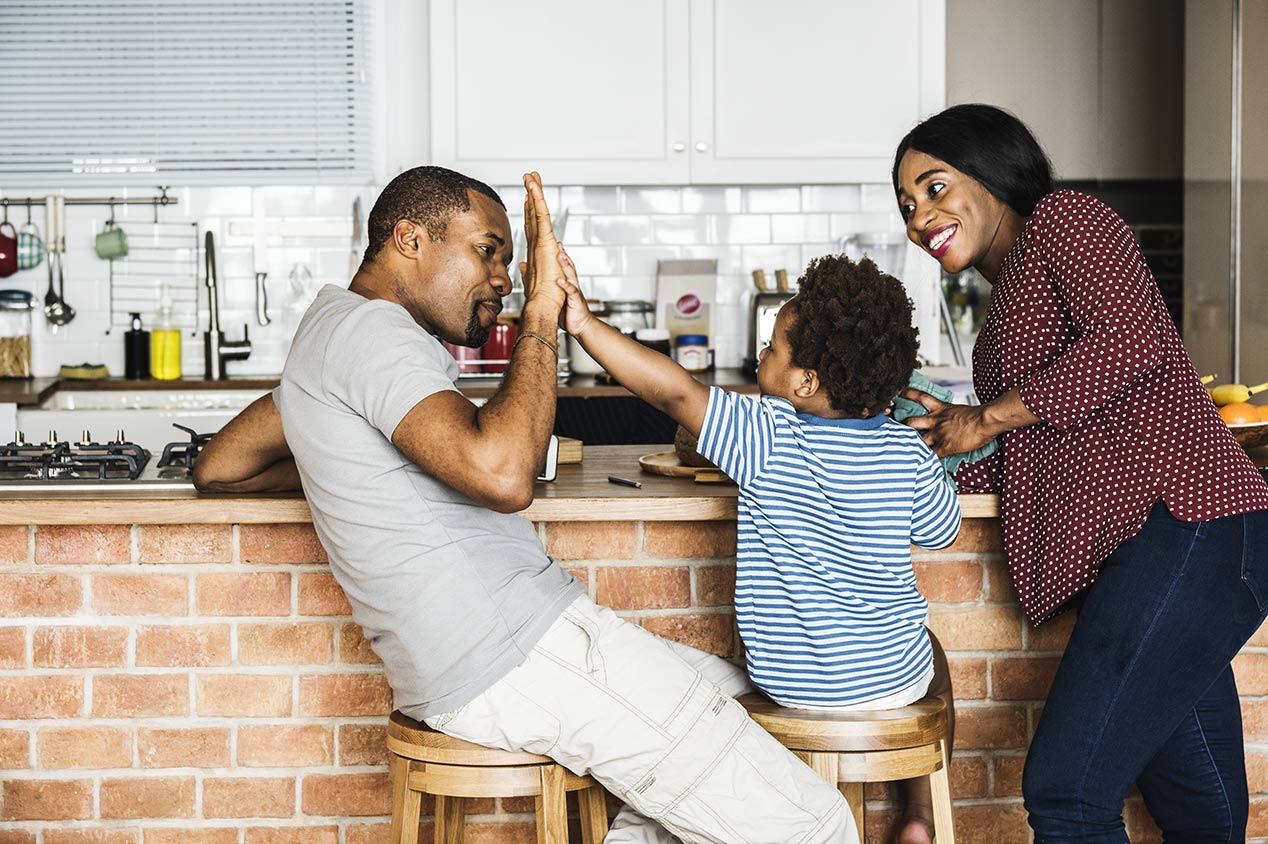 Family laughs and spends time together in kitchen