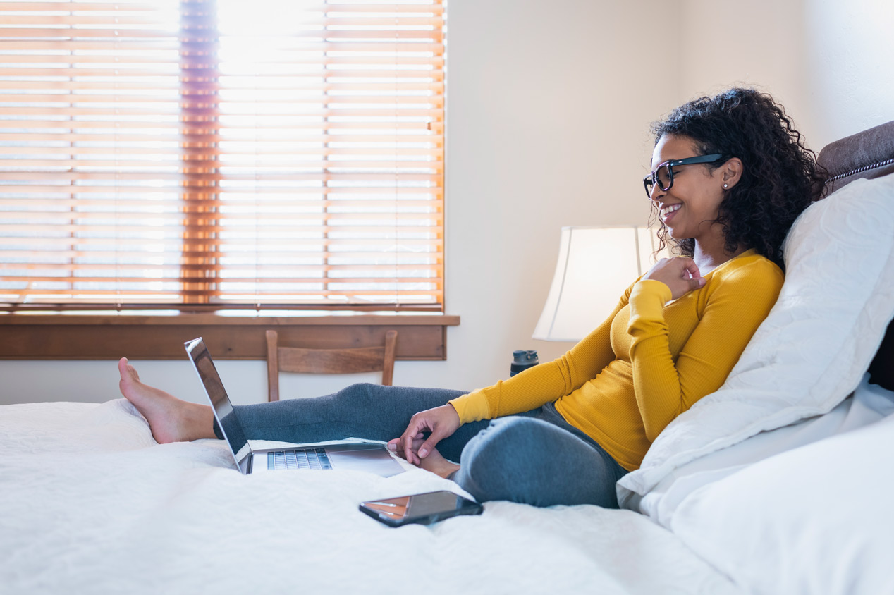 Young woman using her laptop in the bedroom