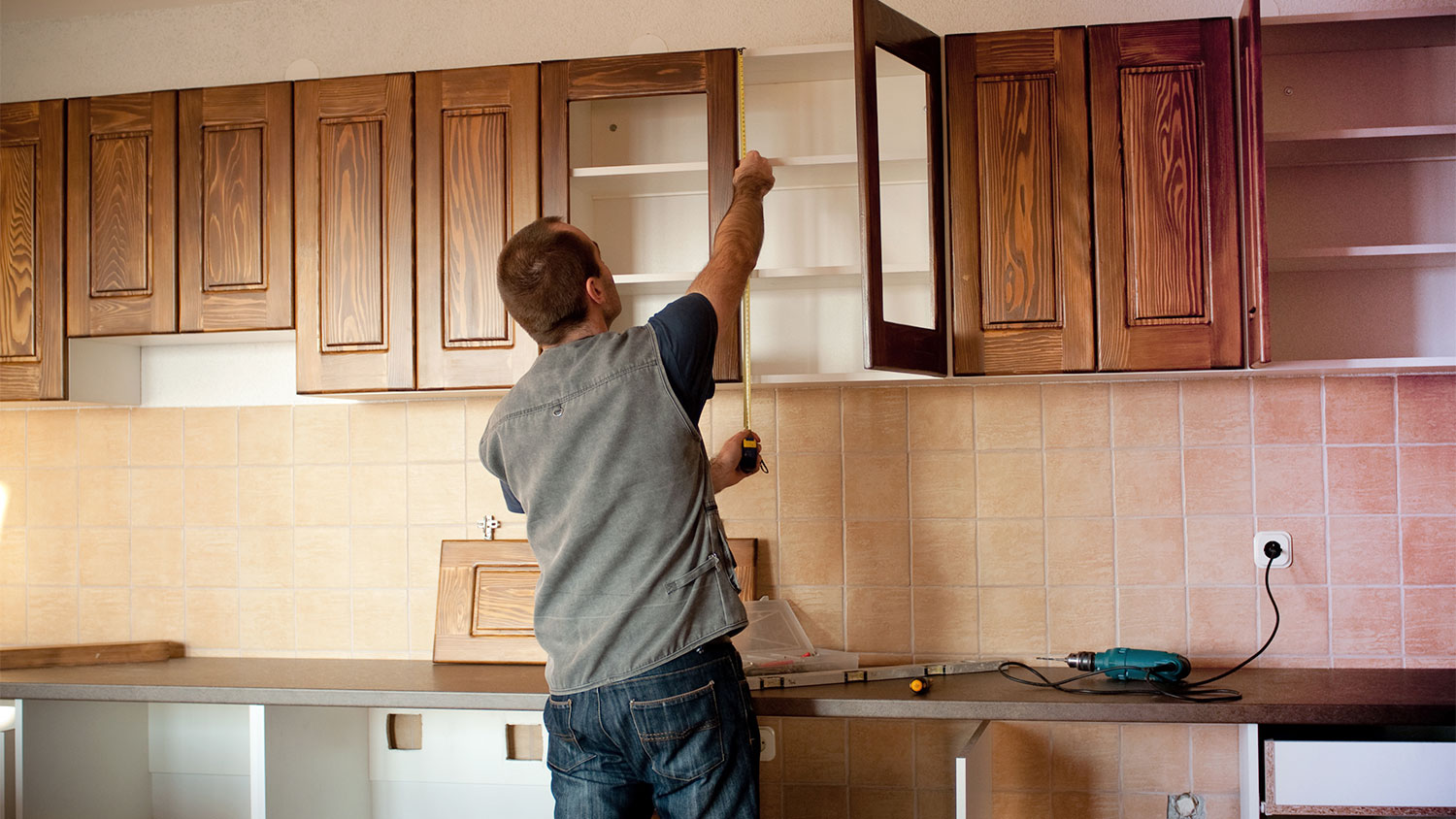 Carpenter installing new kitchen cabinets