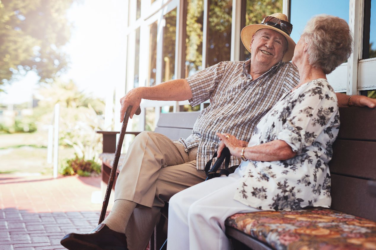 elderly man and woman sitting on bench