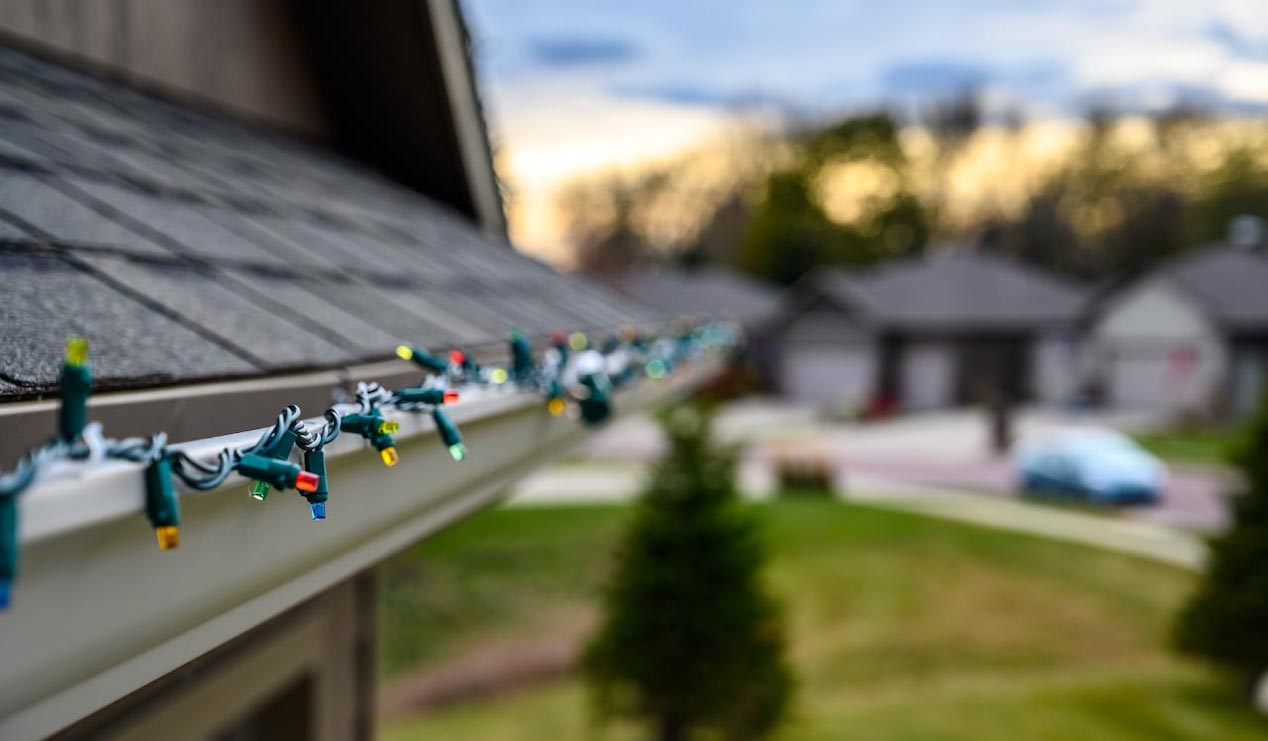 Closeup of holiday lights wrapped around house roof