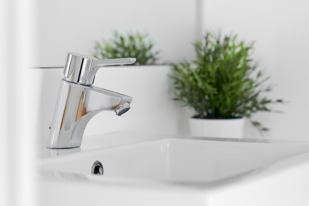 Close-up of a faucet and a basin in a bathroom